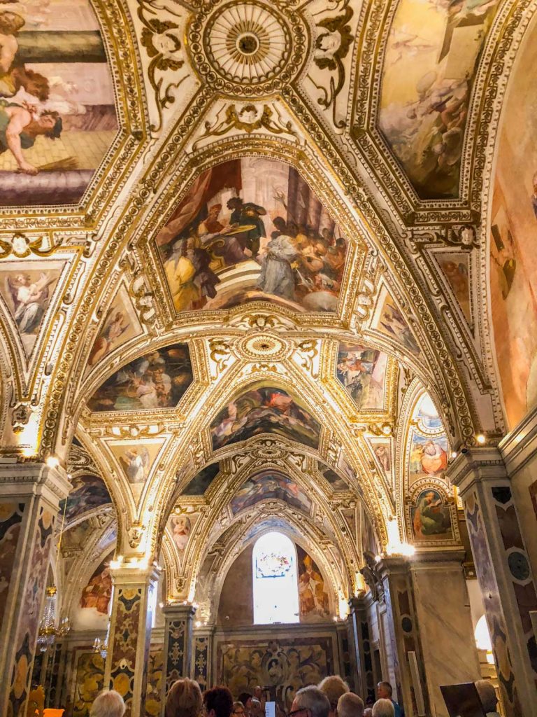 Positano Or Amalfi: Where To Stay & Which Is Better? 33 The lavish interior of Amalfi Cathedral, featuring a gold-adorned ceiling with intricate frescoes and detailed architectural designs.