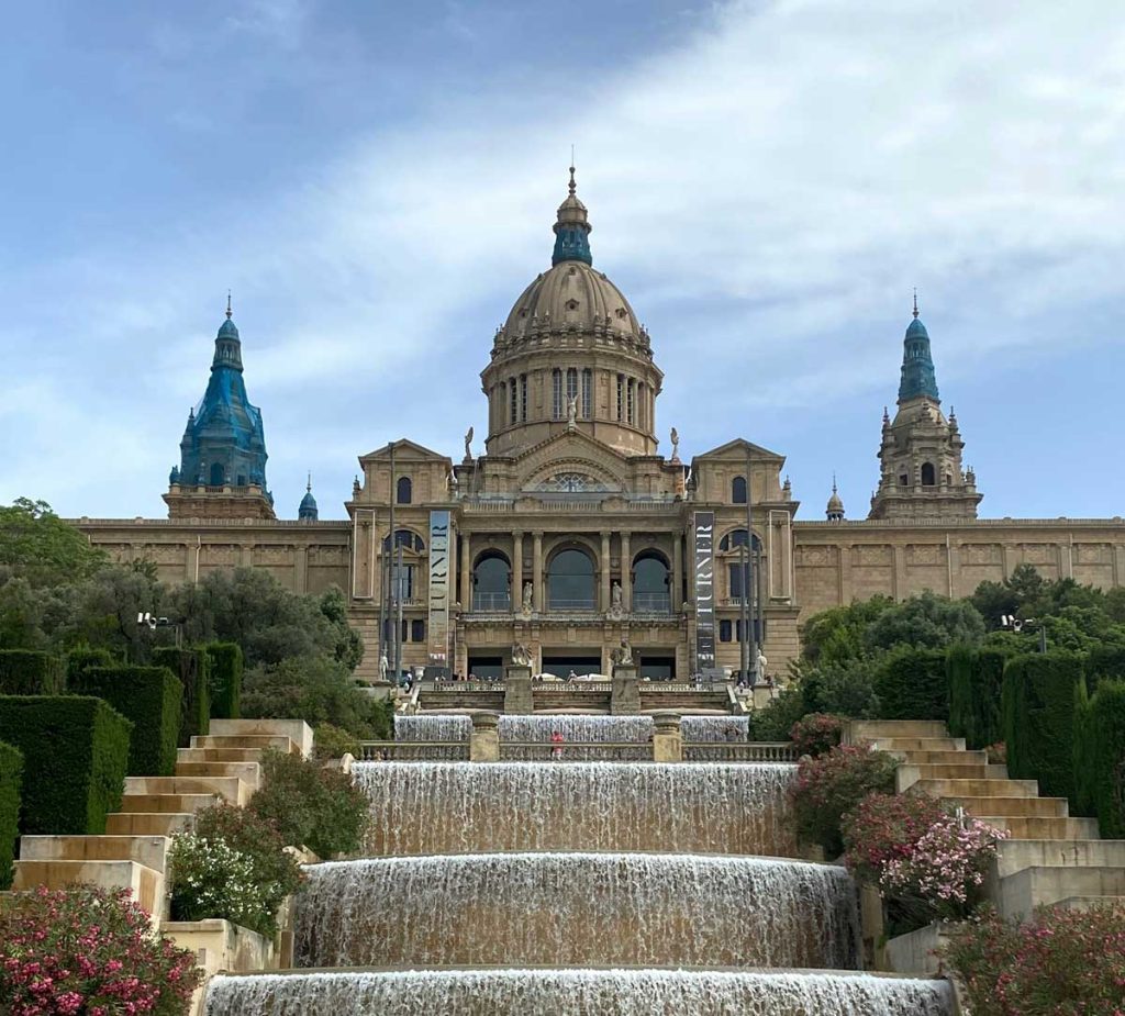 3 Days in Barcelona: The Perfect Itinerary for First-Time Visitors 36 A historic fortress perched atop Montjuïc hill, overlooking Barcelona. The stone walls and watchtowers stand against a partly cloudy sky, with lush greenery surrounding the site.