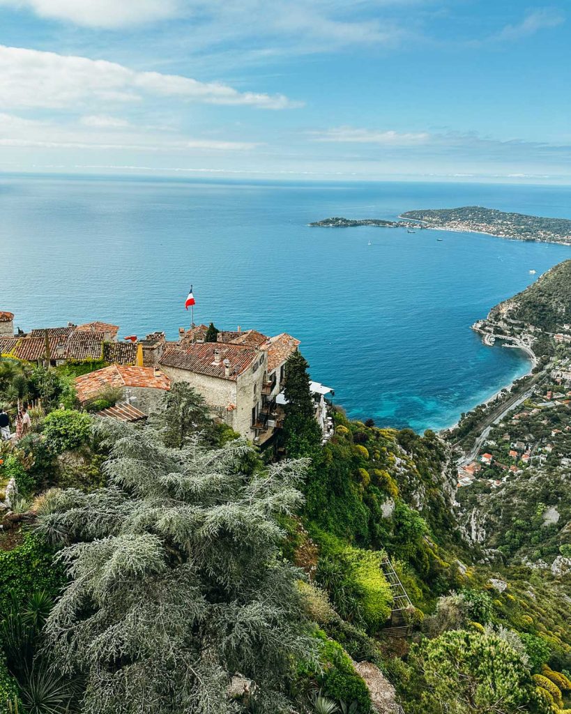 20 Best European Summer Destinations To Visit This Year 25 A cliffside village with terracotta rooftops overlooks a brilliant blue sea and rugged coastline below. This dramatic coastal view captures the magic of Mediterranean European summer destinations.