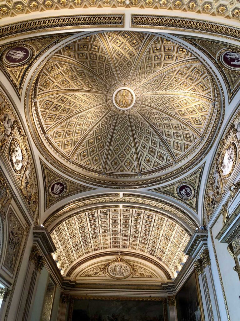 The Perfect 3 Day Florence Itinerary (From an Italy Travel Expert) 15 Ornate arched ceiling inside a Florence museum with gold geometric panels, carved details, and oval paintings. The decorative ceiling draws the eye upward with repeating patterns and bright gilded trim.